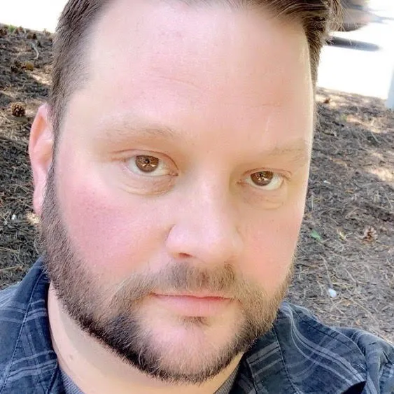 Scott St. John wearing a blue plaid shirt.